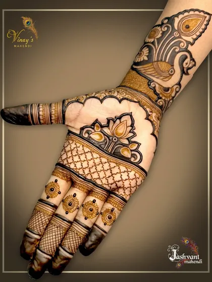 A simple and chic design for the back of the hand. A peacock and lotus motif at the wrist is complemented by delicate patterns on the fingers.