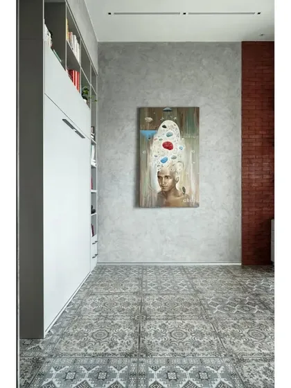 A still image of the multi-functional room when the Murphy bed is closed. The space serves as a chic home office or studio, with the large art piece as the focal point against the concrete-textured wall.