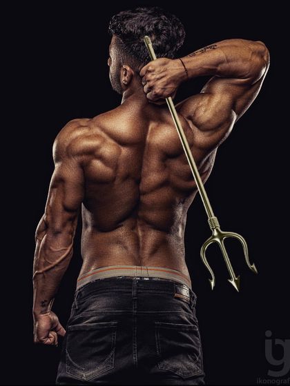 A powerful back shot with a trishul, symbolizing strength and masculinity. This is the kind of powerful physique we build.