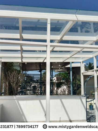 A wide shot of the completed glass pergola, showing how it creates a spacious and protected outdoor living area. The side covering adds privacy from neighbors while maintaining an open feel.