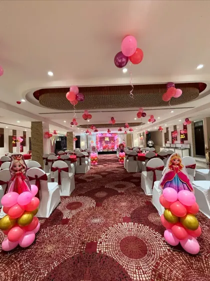 Themed balloon pillars and character cutouts lined the aisle, creating a runway effect for the party.