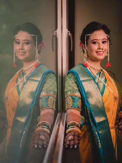 A stunning double-image created with a reflection. This shot perfectly captures the bride's complete look, from her hairstyle to her traditional jewelry.