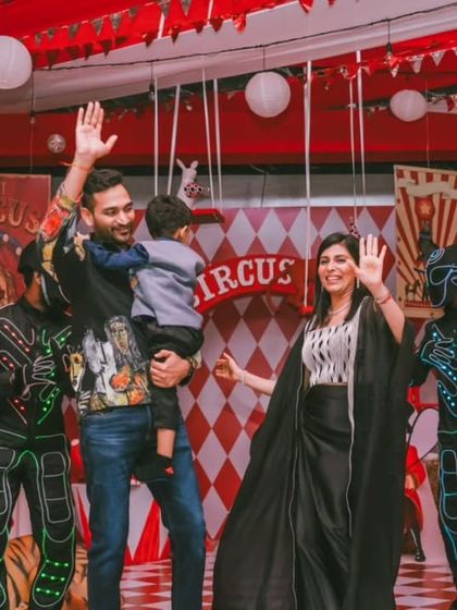 Waving goodbye to an amazing party. The family stands on stage, surrounded by performers, marking the end of a successful and joy-filled celebration.