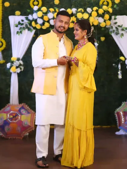 Another full-length shot of the couple, showcasing their coordinated Haldi outfits.