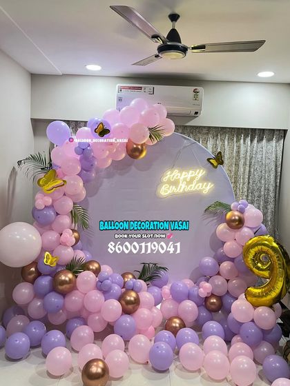 A lovely butterfly theme for a 9th birthday. The round backdrop is decorated with a garland of purple and pink balloons, with gold butterflies and a matching foil number.