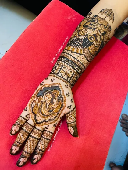 The complete bridal mehendi, showcasing the beautiful flow from the Radha Krishna figure on the palm to the intricate patterns and elephant motif on the arm.