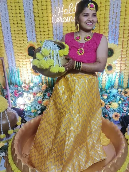 The bride is all smiles, ready for her Haldi ceremony in the traditional 'urli' seating, against our bright and cheerful marigold backdrop.