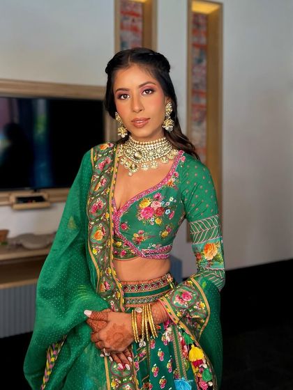 A stunning Mehendi look in a vibrant green lehenga. I love when brides choose unconventional colors. This look features a soft glam eye and a braided hairstyle, perfect for a daytime event at Devi Ratn, Jaipur.