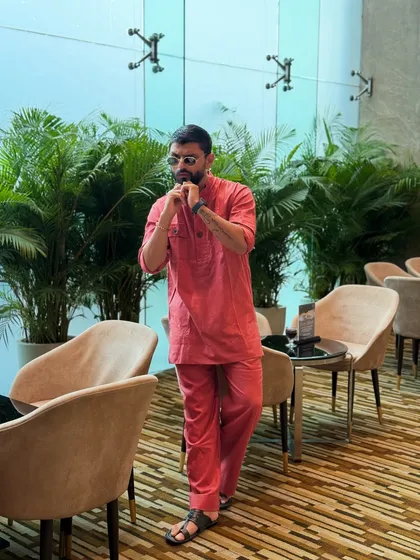 Adjusting the collar on my red kurta. It's the small details that complete a look.