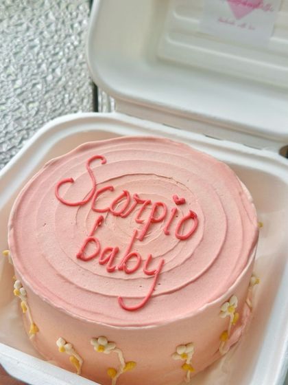 A pretty pink bento cake for a 'Scorpio baby'. We love creating custom zodiac cakes with delicate floral details around the edges.