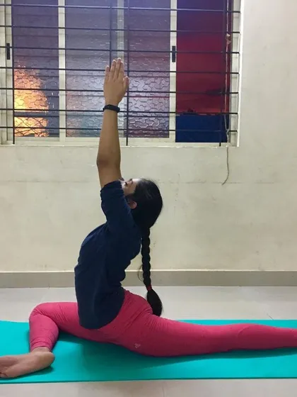 Another student holding Ekapadasana with arms raised, opening the chest.
