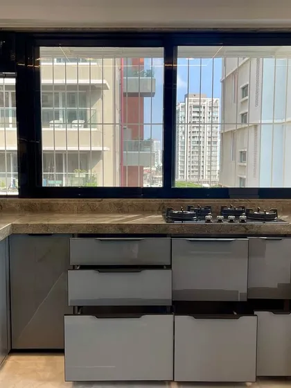 A wide view of the kitchen in Matunga East, showing the ample counter space and natural light from the window.