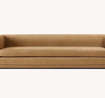 This sofa is clean, uncluttered, and a singular fluid form. Its U-shaped frame curves continuously from the arms to the base, embracing the silhouette, while a recessed plinth creates a striking shadow line.