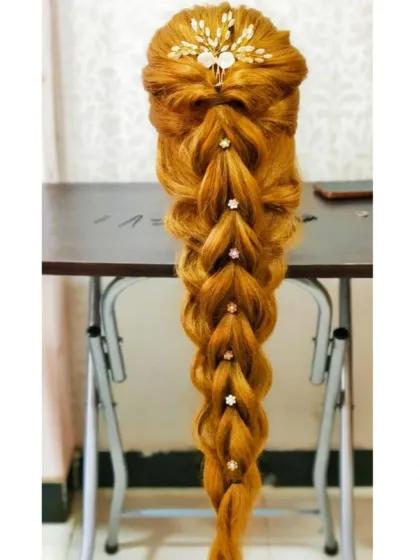 A long, intricate braid created on a mannequin. This demonstrates the technical skill required for advanced braiding, a popular choice for brides.