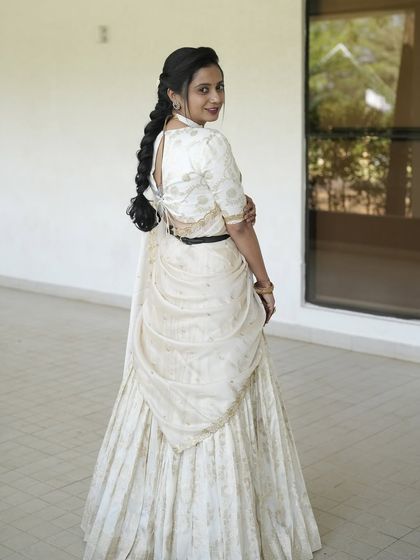My dear friend Nithya shines in this custom-made light gold lehenga. I designed it with a modern, draped dupatta that can be belted at the waist, creating a look of effortless elegance for her special event.