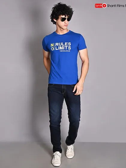 A classic e-commerce shot for a men's graphic t-shirt. The walking pose adds a touch of movement, while the direct lighting ensures the text on the shirt is perfectly legible.