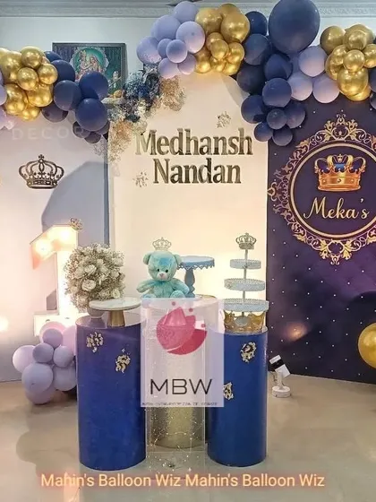 The main stage for the royal prince theme, complete with a personalized backdrop, throne-like pedestals, and a matching balloon arch.