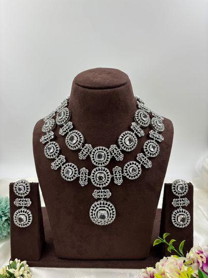 This bold, silver-plated AD set features large circular motifs. It's a statement piece available in sapphire blue, emerald green, ruby red, and all-white, perfect for customers who want to stand out.