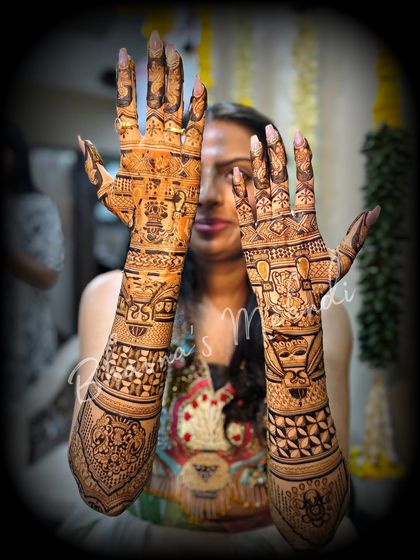 A bride showcasing her full wedding mehndi. The designs are dense, detailed, and filled with personal stories and traditional symbols.