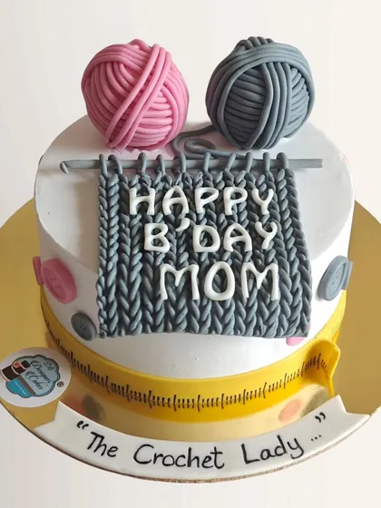 A cozy crochet-themed cake for "The Crochet Lady". This design features fondant yarn balls and a knitting pattern, perfect for a mom who loves to knit.