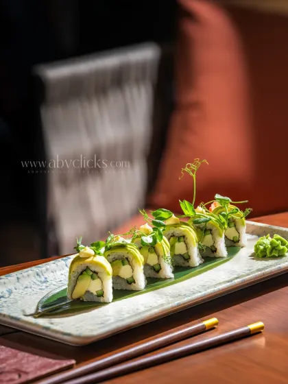 Avocado and cream cheese sushi rolls from Camo, Noida. The shallow depth of field creates a sophisticated, moody atmosphere.