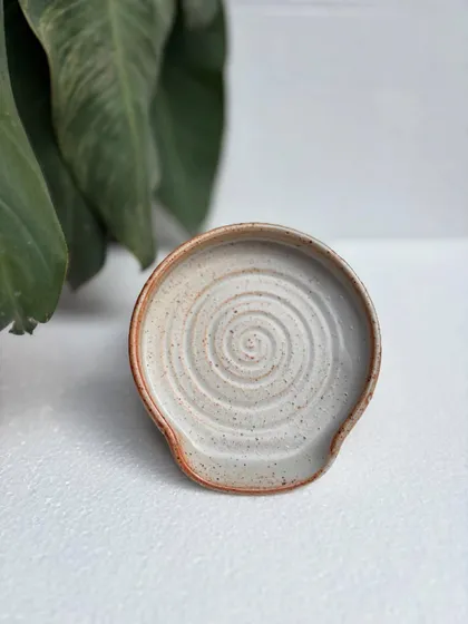 A spoon rest in our studio-made Shino glaze. The throwing rings are clearly visible, and the warm, toasty color is beautiful.