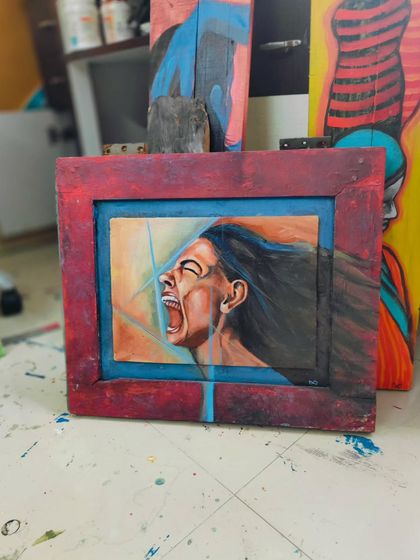 An older piece, an oil painting of a woman screaming, framed in reclaimed wood. It’s a raw expression of rage and the need to be heard. This work is currently available for sale.