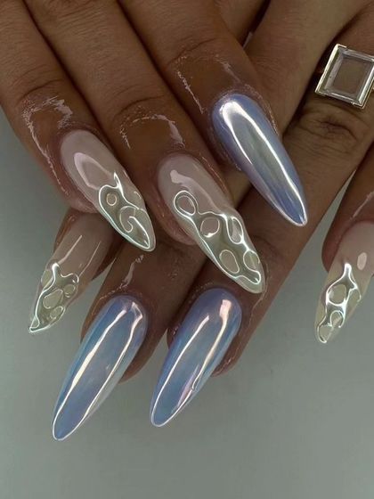 These long, stiletto nails feature a pearlescent, holographic chrome finish. The design is enhanced with 3D clear flame details, creating a unique and otherworldly look.