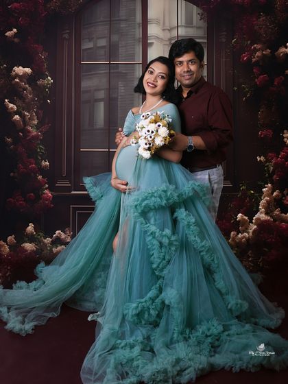 A romantic portrait of the couple surrounded by a rich, floral background. The teal gown and deep red shirt create a beautiful, moody color palette.