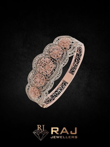 A wide bangle mounting with intricate floral filigree work in rose and white gold. This piece offers a substantial canvas for creating a detailed and luxurious custom bangle.