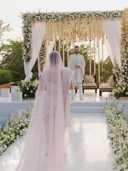 The bride's grand entrance, walking towards the groom at the Hilton Goa. This shot, part of the first-ever Vogue wedding, captures the anticipation and the stunning poolside ceremony setup.