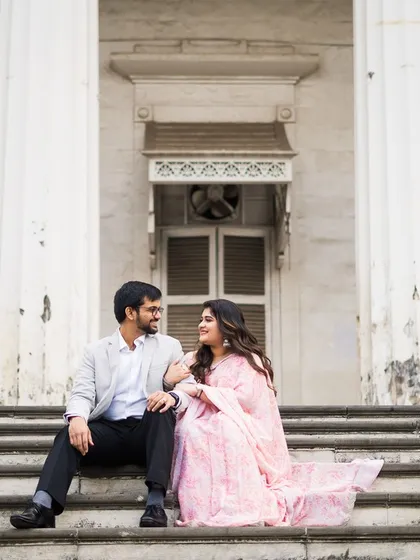 Sitting on the steps of a colonial-era building, the couple shares a look. We use historic locations to add depth and character to our pre-wedding photography.