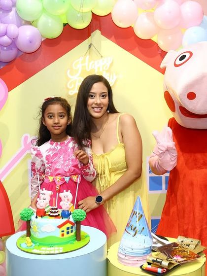 The birthday girl gets a photo with her mom and Peppa Pig next to the themed cake. It's a perfect snapshot of a dream come true.