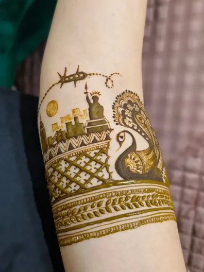 A close-up of an arm band featuring the New York City skyline and the Statue of Liberty, representing the bride's journey from India to the USA.