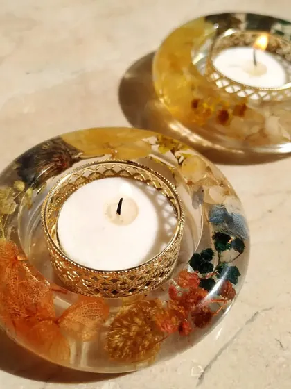 This pair of round floral diyas showcases how different flower combinations can create unique looks. The warm, earthy tones of the flowers are beautifully illuminated by the candlelight.