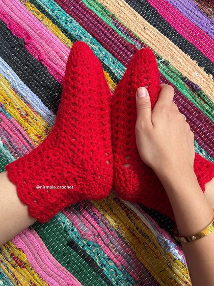 Our lace crochet socks in a vibrant red. The delicate, airy pattern and scalloped edge make them a beautiful and comfortable choice for wearing around the house.