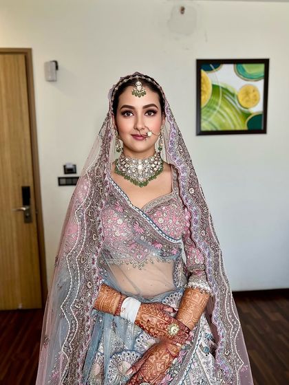 A frontal view of the beautiful bride, showing how the clean hairstyle and dupatta setting create a perfect frame for her face.
