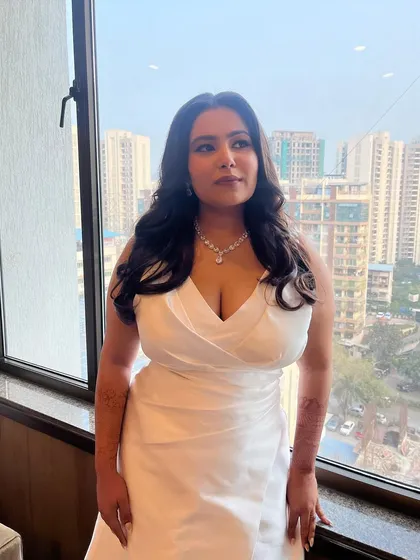 A beautiful shot by the window. The natural light highlights the glowing skin and the soft waves in her hair, creating a dreamy and romantic portrait.