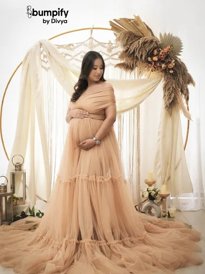 A quiet, solo moment for the mom-to-be. She looks down at her bump, lost in thought, creating a beautiful and emotional portrait.