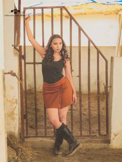A model poses by the stable gates, capturing a "Wild West" vibe. The rustic architecture of our stables provides an authentic backdrop for themed photoshoots.