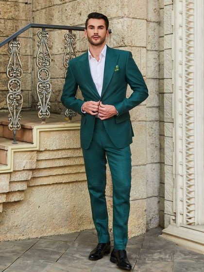 A full-length view of the green linen suit, showcasing its sharp, modern silhouette. The bespoke fit ensures a clean line from shoulder to ankle.