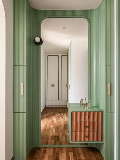 A closer look at the custom fluted vanity area, with its mix of green paint and natural wood drawers, reflecting the playful material palette of the room.