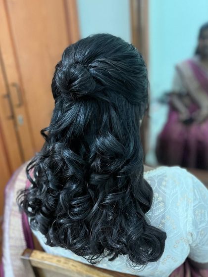 Another angle of this curly half-updo. The style is elegant and keeps the hair off the face while still showing off its length and texture.