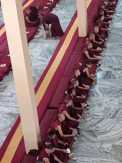A view of the Sangha at Sera Jey Monastery during a formal ceremony. This image shows hundreds of monks seated in rows for a meal, reflecting the profound tradition, discipline, and scale of monastic life that our center is connected to.