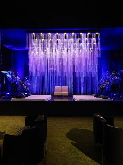Lighting is one of my most powerful tools. This stage features a curtain of cascading crystal strings that shimmer and catch the light, creating a backdrop that is both modern and deeply romantic, perfect for a sangeet or reception.