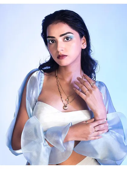 A detailed portrait focusing on the layered necklaces and rings. This shot is perfect for highlighting how accessories complete a look, while the model's soft expression adds a touch of allure.