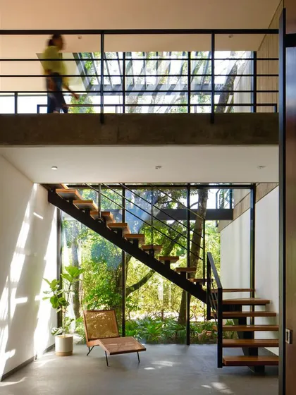 The view from this modern staircase is of a lush, green jungle. We use large glass panels to ensure that the beauty of the outdoor landscape is a constant feature of the indoor experience.