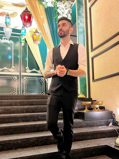 Taking a moment before my set at a grand wedding venue. I always arrive early to get a feel for the space and ensure my setup is perfect before the guests arrive. My formal waistcoat and shirt combo is ideal for such elegant events.
