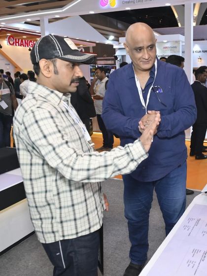 An attendee gets a close-up look at a home theatre projector setup, evaluating its performance and design for potential integration.