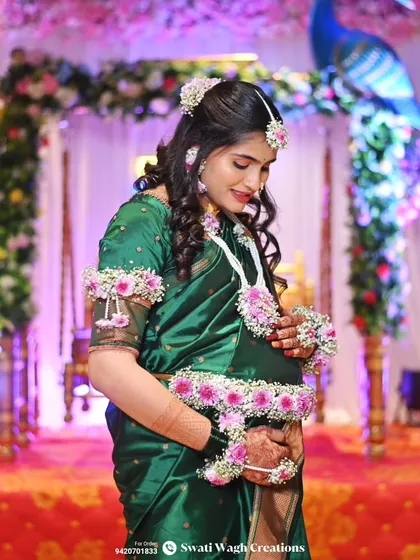 Mommy glow. This beautiful client chose a delicate pink floral set that perfectly complements her green saree for her baby shower.